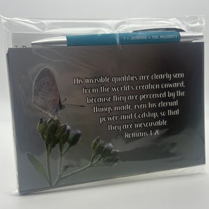 May include: A gray card with a butterfly and a quote from Romans 1:20. The quote reads: "His invisible qualities are clearly seen from the world's creation onward, because they are perceived by the things made, even his eternal power and Godship, so that they are inexcusable." - Romans 1:20