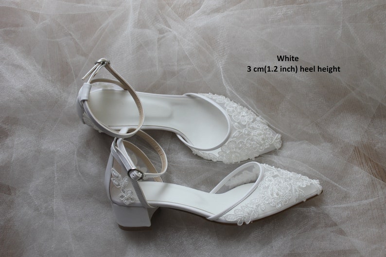 May include: White bridal shoes with a lace design and a 3 cm (1.2 inch) heel height.