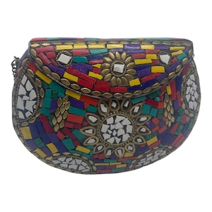May include: A semi-circular clutch bag featuring a vibrant mosaic pattern of red, yellow, blue, green, and white tiles. The surface is decorated with brass-toned metal accents arranged in floral shapes and a metallic chain strap on the side.
