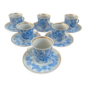 Peut inclure: Ensemble de six tasses à thé et soucoupes en porcelaine blanche avec des motifs floraux bleus et dorés.