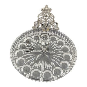 Op de afbeelding: Een glazen serveerschaal met een decoratief, versierd zilveren kroonvormig handvat. De schaal heeft een stervormig patroon en is in vier secties verdeeld.