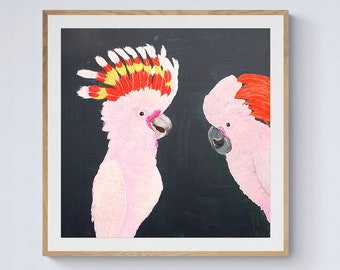 May include: A framed artwork featuring two pink cockatoos with red and yellow crests against a black background. The artwork hangs above a teal sofa with wooden legs. A tall glass vase holds a single pink flower.