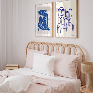 a bed with pink sheets and pillows in a bedroom