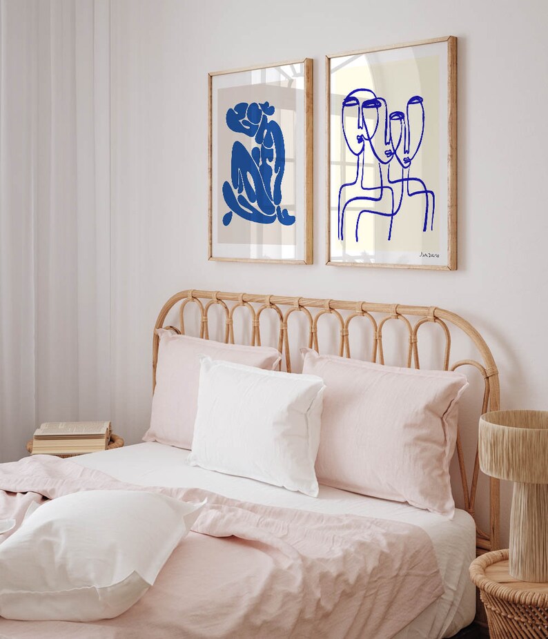 a bed with pink sheets and pillows in a bedroom