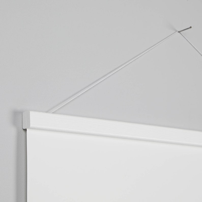 May include: White hanging canvas with a white wooden frame and a thin white string attached to the top.