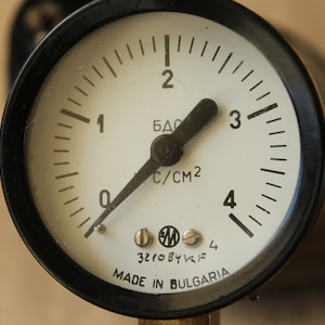 Può includere: Un manometro rotondo nero e bianco con un ago nero. Il manometro legge fino a 4 bar ed è etichettato "MADE IN BULGARIA".