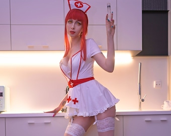May include: A woman dressed as a nurse in a white dress with red accents and a red nurse's hat. She is holding a syringe and wearing white stockings and white platform heels.