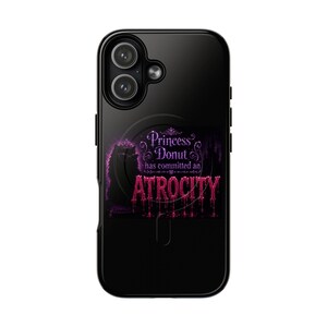 May include: A black smartphone case featuring a graphic design with a purple crown and the text Princess Donut has committed an ATROCITY in pink glittery, dripping lettering. The design includes a silhouette of a cat wearing a crown.
