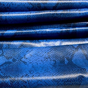 Könnte beinhalten: Blauer Kunstlederstoff mit Schlangenhautmuster.