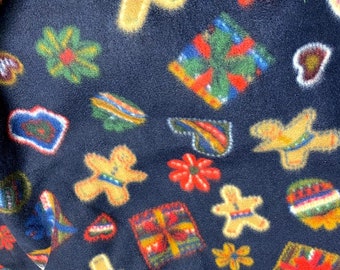 May include: A dark blue fleece fabric with a repeating pattern of gingerbread men, presents, flowers, and hearts. The fabric is soft and fuzzy and would be perfect for a holiday project.