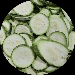 May include: A bowl filled with dried zucchini slices. The slices are light green and have a slightly translucent appearance.
