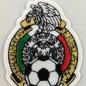May include: Embroidered patch featuring the Mexican national football team logo. The logo is a white circle with a black football in the centre, surrounded by a green, white and red ring with the words "Federacion Mexicana de Futbol Asociacion" in gold lettering.