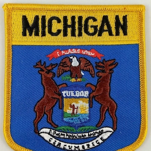 Peut inclure: Un écusson brodé bleu et jaune avec le sceau de l'État du Michigan. Le sceau représente un aigle chauve, deux wapitis et un bouclier avec le mot "Tuebor" dessus. Le texte "MICHIGAN" est brodé en noir sur un fond jaune.