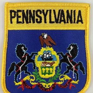 Peut inclure: Un écusson brodé jaune et bleu avec le sceau de l'État de Pennsylvanie. Le sceau représente un aigle chauve, deux chevaux et un navire. Le texte "PENNSYLVANIA" est brodé en noir sur fond jaune.