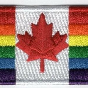 May include: Embroidered patch featuring a rainbow-colored Canadian flag with a red maple leaf in the center. The rainbow colors are red, orange, yellow, green, blue, and purple.