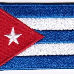 Peut inclure: Un écusson brodé représentant le drapeau cubain. Le drapeau est rouge, blanc et bleu avec une étoile blanche sur un triangle rouge dans le coin supérieur gauche et cinq bandes bleues et blanches alternées.