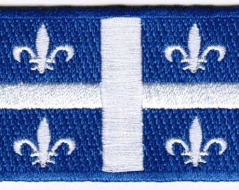May include: Embroidered blue patch featuring the flag of Quebec. The design includes four white fleur-de-lis symbols and a white cross on a blue background. The patch has a blue border.