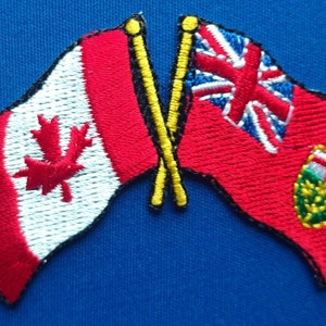 以下が含まれることがあります： カナダの国旗とイギリスの国旗が刺繍された2つのパッチが、互いに交差しています。