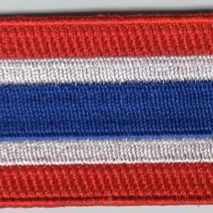 以下が含まれることがあります： タイの旗を刺繍したパッチ。赤、白、青のストライプが特徴です。