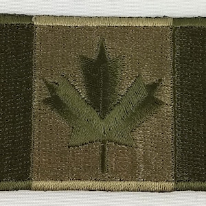 Peut inclure: Un écusson de drapeau canadien camouflage vert avec une feuille d'érable cousue.