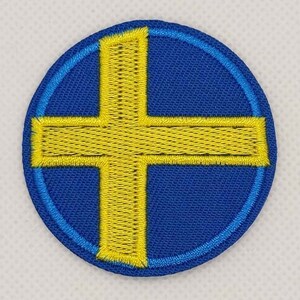 May include: A round blue patch with a yellow cross in the center. The cross is outlined in yellow and the patch is outlined in blue.
