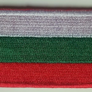 以下が含まれることがあります： ブルガリアの国旗が刺繍されたパッチ。長方形のパッチは、白、緑、赤の水平ストライプを白い縁取りで表示しています。色は鮮やかで、ステッチは詳細です。
