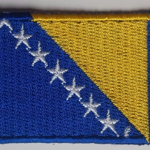 May include: Embroidered patch featuring the flag of Bosnia and Herzegovina. The design includes a blue rectangle with a yellow triangle and white stars. The patch has a blue border.