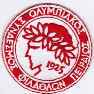 Può includere: Toppa ricamata rossa e bianca con il testo "ATHLITIKOS OLYMPIACOS PIREOS" e "1925" in un cerchio. Il centro della toppa presenta una silhouette rossa di una persona che indossa una corona di alloro.