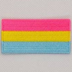 May include: A small, rectangular patch with three horizontal stripes. The top stripe is pink, the middle stripe is yellow, and the bottom stripe is light blue.