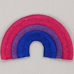 May include: A small embroidered patch in the shape of a rainbow with pink, purple, blue, and white stripes.