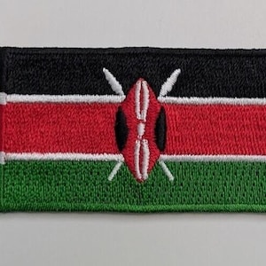 May include: Embroidered patch of the Kenyan flag. The flag is black, red, and green with a white stripe between the red and green. The centre of the flag features a white shield with two spears and a traditional Maasai warrior's shield.