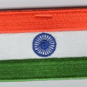 Può includere: Toppa ricamata con la bandiera indiana. La toppa rettangolare mostra il design tricolore della bandiera: una banda superiore arancione, una banda centrale bianca con una ruota blu e una banda inferiore verde. I bordi sono cuciti con cura.