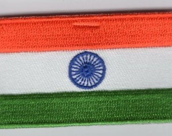 May include: Embroidered patch of the Indian flag. The rectangular patch shows the flag's tricolour design: an orange top band, a white middle band with a blue wheel, and a green bottom band. The edges are neatly stitched.