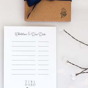 May include: A white notepad with a black line design and the text "Children & Due Date" at the top. The notepad has a black and white logo at the bottom that says "Tibi Dabo Studio" with a key icon and the website address "www.tibidabostudio.com".