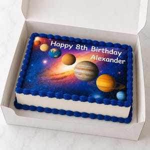 以下が含まれることがあります： 青い縁取りと「Happy 8th Birthday Alexander」の文字が入った長方形のバースデーケーキ。 ケーキは、星空の銀河の背景に惑星の食べられる画像が特徴です。 ケーキは白い箱の中に入っています。