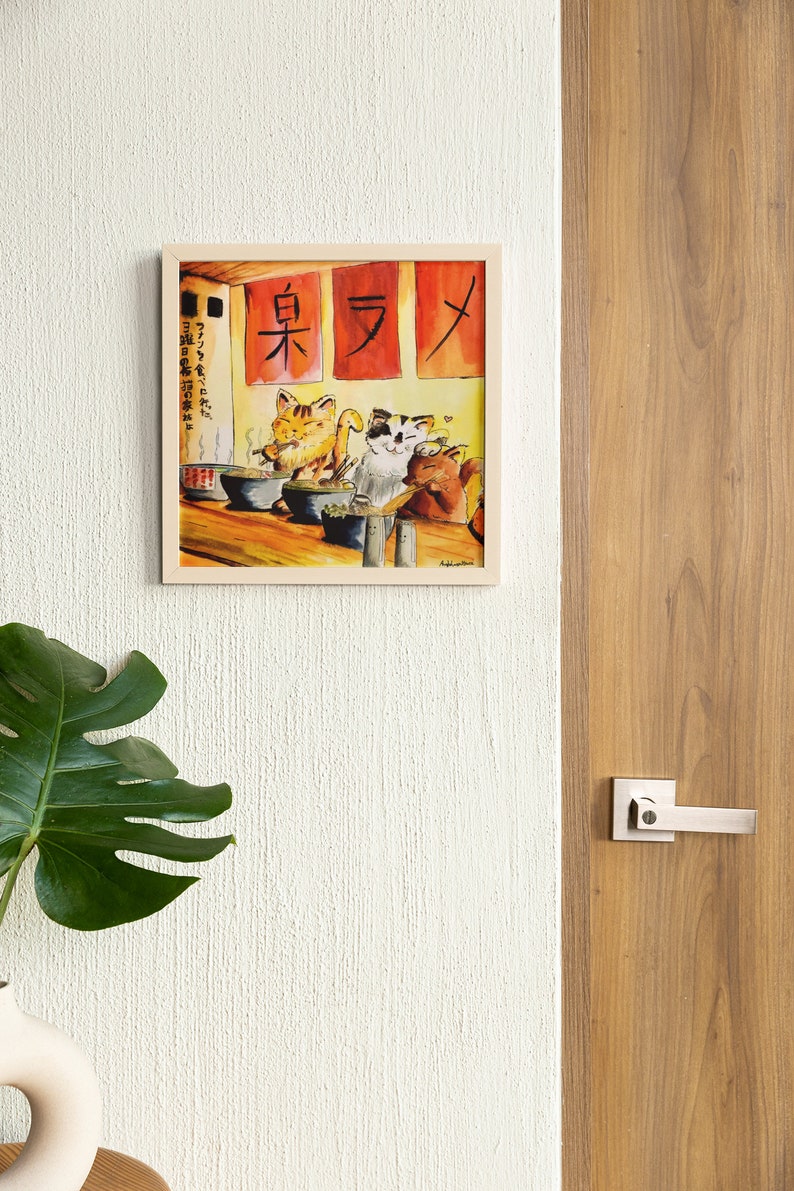 May include: A framed watercolor painting of three cats eating ramen in a restaurant. The restaurant has red signs with Japanese characters that read "東 ラ メ" (East Ramen).