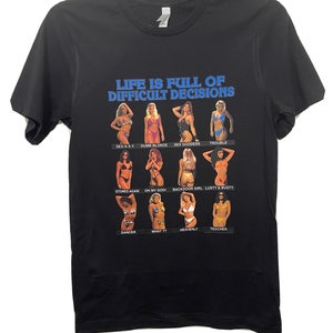May include: Black t-shirt with a graphic print of women in swimsuits and the text "Life is full of difficult decisions".