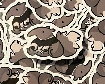 May include: A collection of black and white stickers featuring a cartoon anteater with a long snout and curled tail. The stickers are printed on white paper and have a glossy finish.