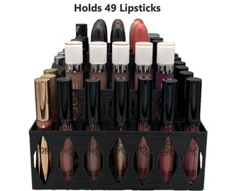 May include: Black lipstick organizer with 49 slots, holding various colored lipsticks. The organizer is labeled "Holds 49 Lipsticks".