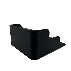 May include: A black plastic tiered storage organizer with three levels. The organizer is designed to hold small items, such as toiletries or office supplies.