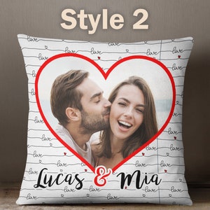 Puede incluir: Almohada blanca con l&iacute;neas negras y corazones rojos. La almohada tiene una foto de una pareja en forma de coraz&oacute;n con el texto "Lucas & Mia" debajo de la foto.