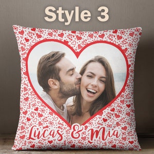 Puede incluir: Almohada blanca con un marco rojo en forma de coraz&oacute;n que contiene una foto de una pareja. El fondo de la almohada est&aacute; cubierto de corazones rojos y el texto "You & Me". El texto "Lucas & Mia" est&aacute; impreso debajo del coraz&oacute;n.