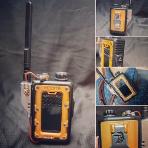May include: A black and yellow two-way radio with a long antenna. The radio has the word "NOKOTR" printed on it, along with other text and a graphic. The radio has a clip on the back and a small screen.