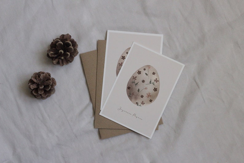 carte Joyeuses Pâques dessin d'un oeuf peint à l'aquarelle avec des motifs floraux dessus et avec le texte Joyeuses Pâques dessous.