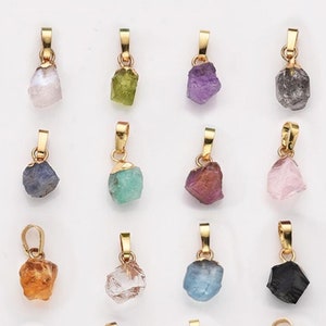 Peut inclure: Un ensemble de 16 pendentifs plaqués or avec différentes pierres précieuses brutes non taillées. Les pierres précieuses comprennent l'améthyste, l'aigue-marine, la cornaline, la citrine, l'émeraude, la fluorine, le grenat, l'hématite, le kyanite, l'obsidienne, le péridot, le quartz rose, le quartz fumé, la turquoise et le quartz clair.