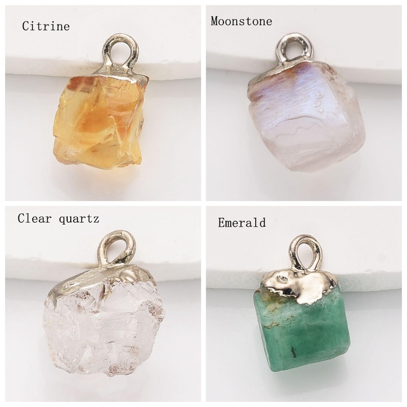 May include: Four different gemstone pendants with silver jump rings. The pendants are Citrine, Moonstone, Clear Quartz, and Emerald.