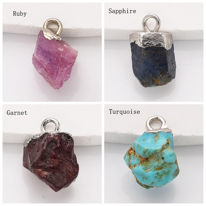 May include: Four gemstone pendants with silver bail loops. The gemstones are ruby, sapphire, garnet, and turquoise.