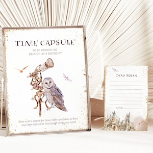 May include: A white card with gold glitter and a black frame. The card has a picture of an owl, a telescope, and a castle. The text on the card reads "Time Capsule To Be Opened On Brian's 18th Birthday". There is a smaller white card with gold glitter that says "Dear Brian" and has lines for writing.