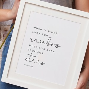 May include: White framed print with a black and white quote that reads "When it rains look for rainbows. When it's dark look for stars. Oscar Wilde."