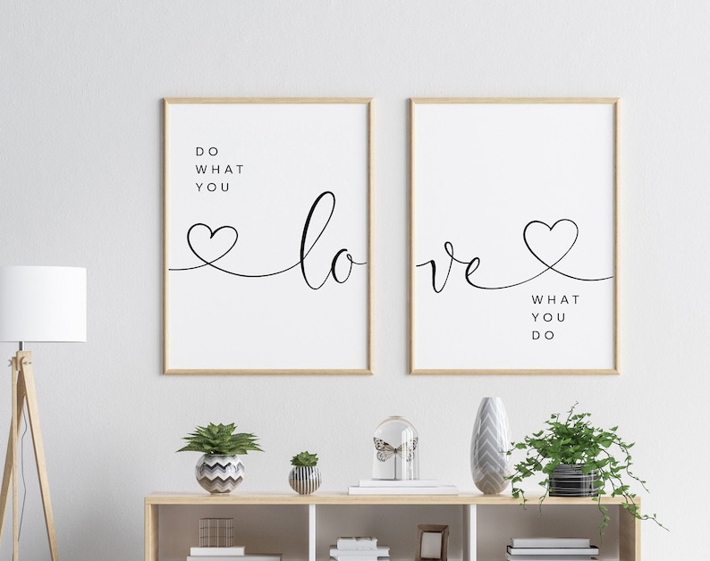 May include: Two framed art prints with the words "Do What You Love" and "Love What You Do" in black script. The word "love" is written with a heart symbol. The frames are a light wood color.